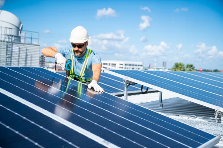 Engineer inspecting solar panels on a roof.