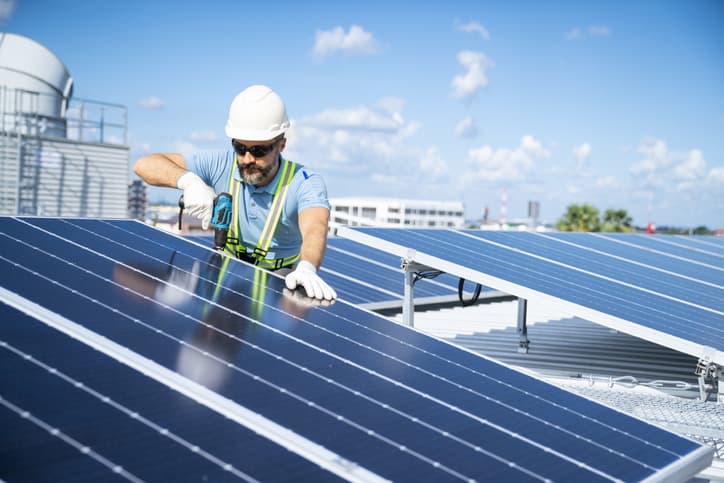 Engineer inspecting solar panels on a roof.